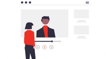 woman standing in front of video screen with a man on the screen